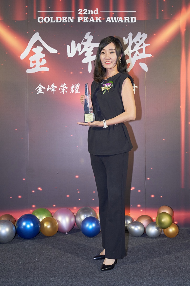 Molly Chen holding a crystal trophy at the 22nd Golden Peak Award