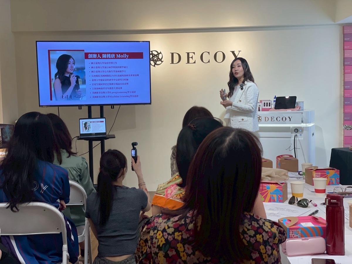 Molly Chen speaking to guests at a Decoy store, guests seen from behind